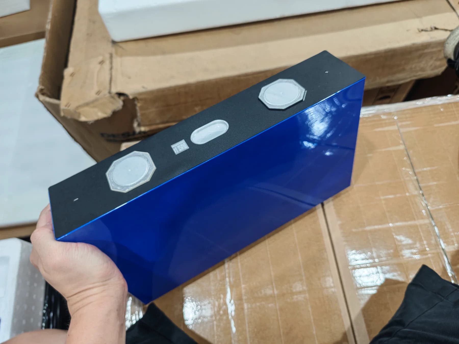 EVE MB56 628Ah large-format LFP cell held for size reference